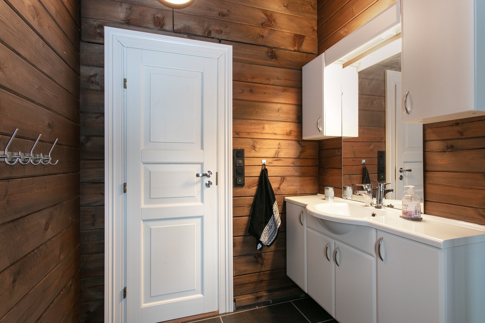 Hvit baderomsinnredning med god skapplass. Speil med overlys og skap over servant Galleribilde