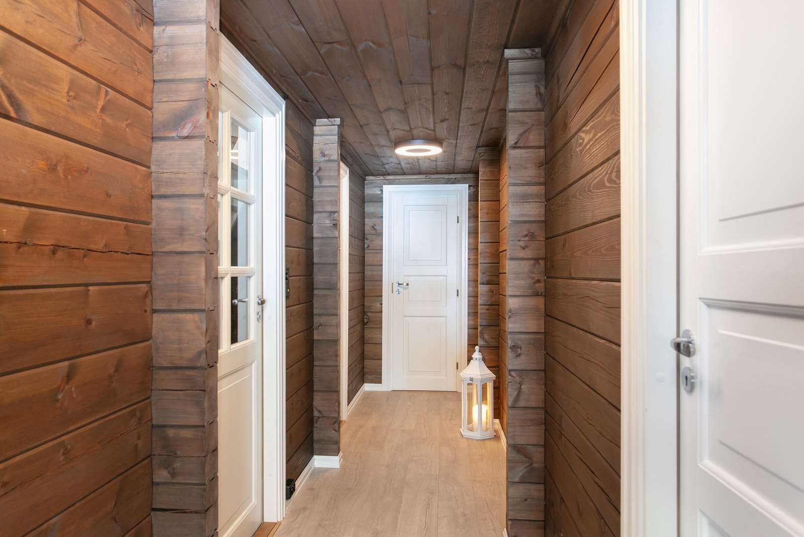 Gang med gulvvarme, panelte vegger og ta. Hvite profilerte innerdører Galleribilde