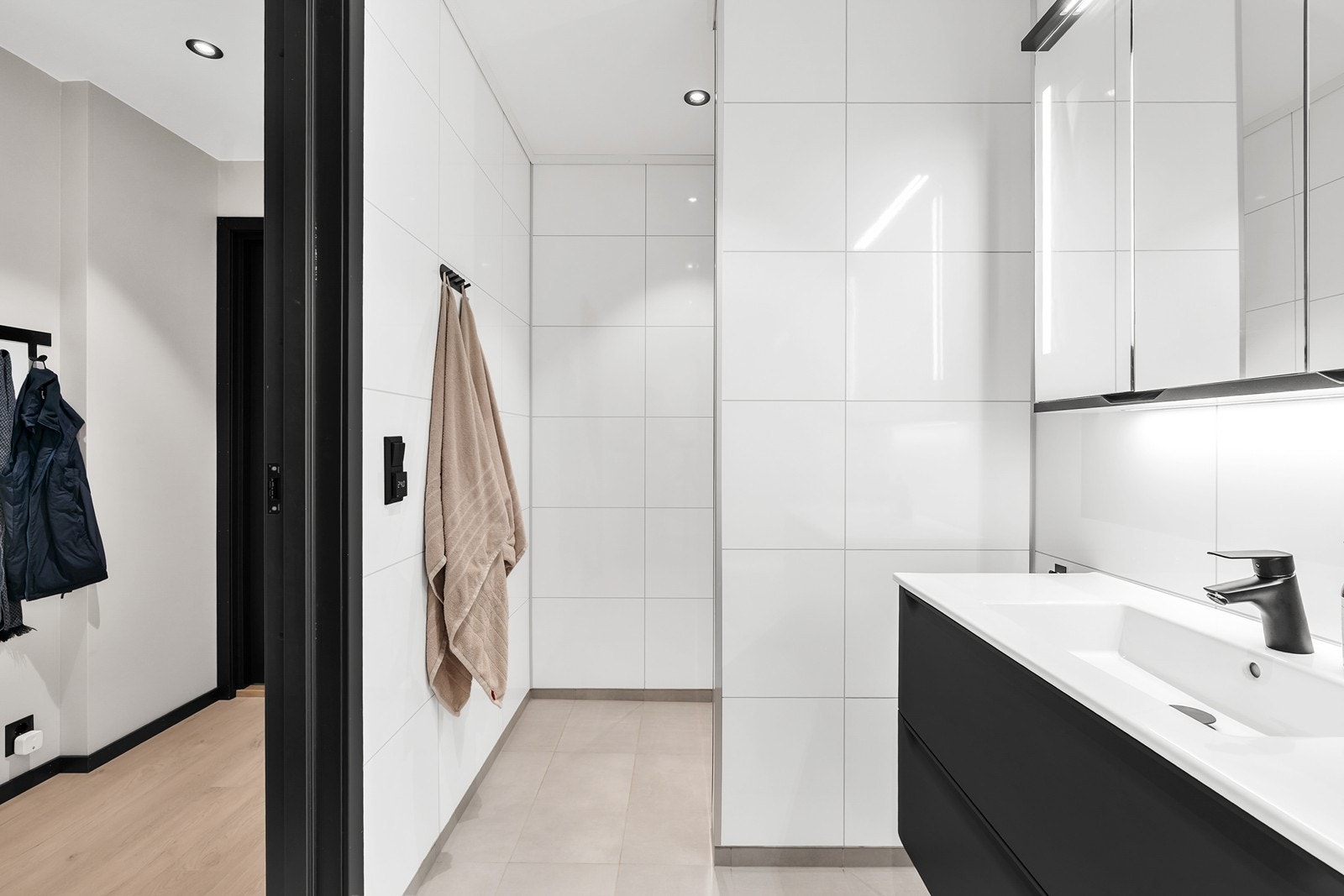 Badet har flislagt gulv med varmekabler, baderomsplater på vegger og malte himlingsplater med innfelte spotter Galleribilde