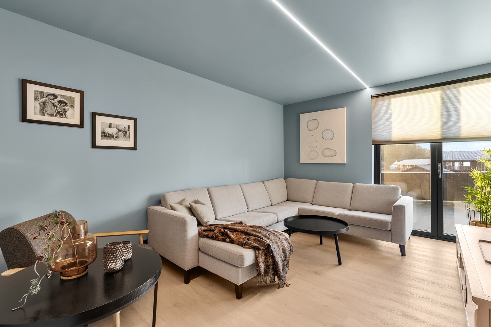 Tv-stuen er malt i en behagelig fargetone med helhetlige fargevalg i gulv og tak. Det er gulvvarme og terrassedører Galleribilde