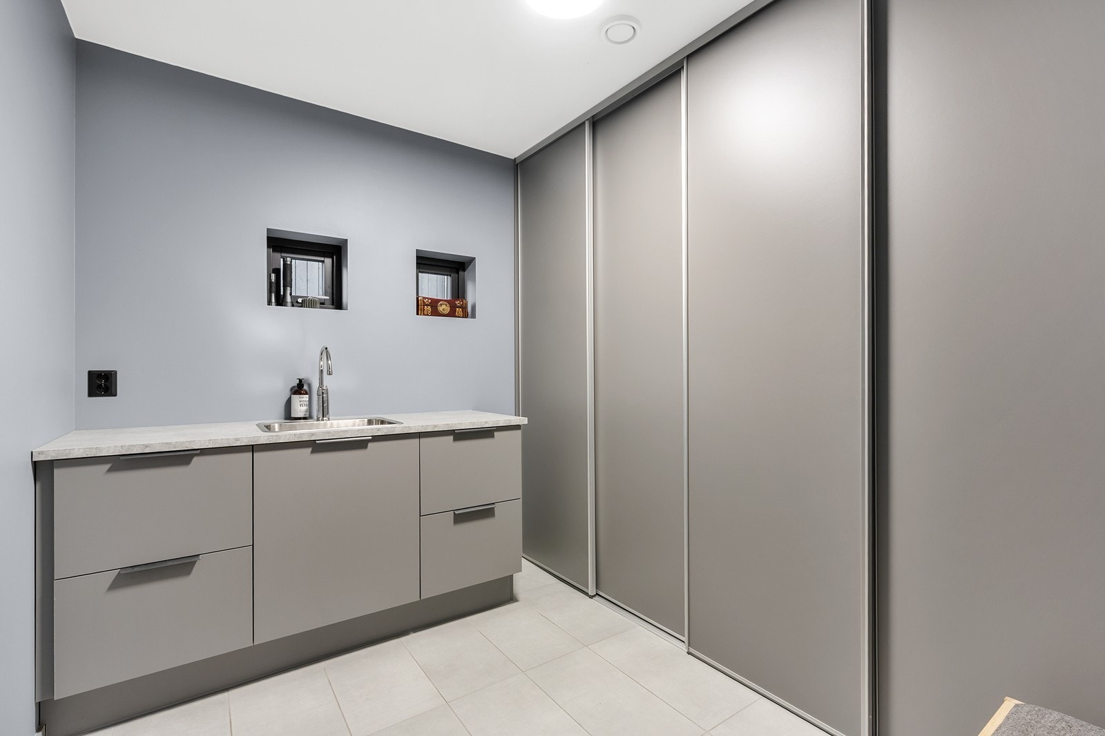 Boligen har et praktisk og pent vaskerom innredet med HTH-innredning, benkeplate, utslagsvask, skyvedører, samt opplegg for vaskemaskin og tørketrommel. Galleribilde