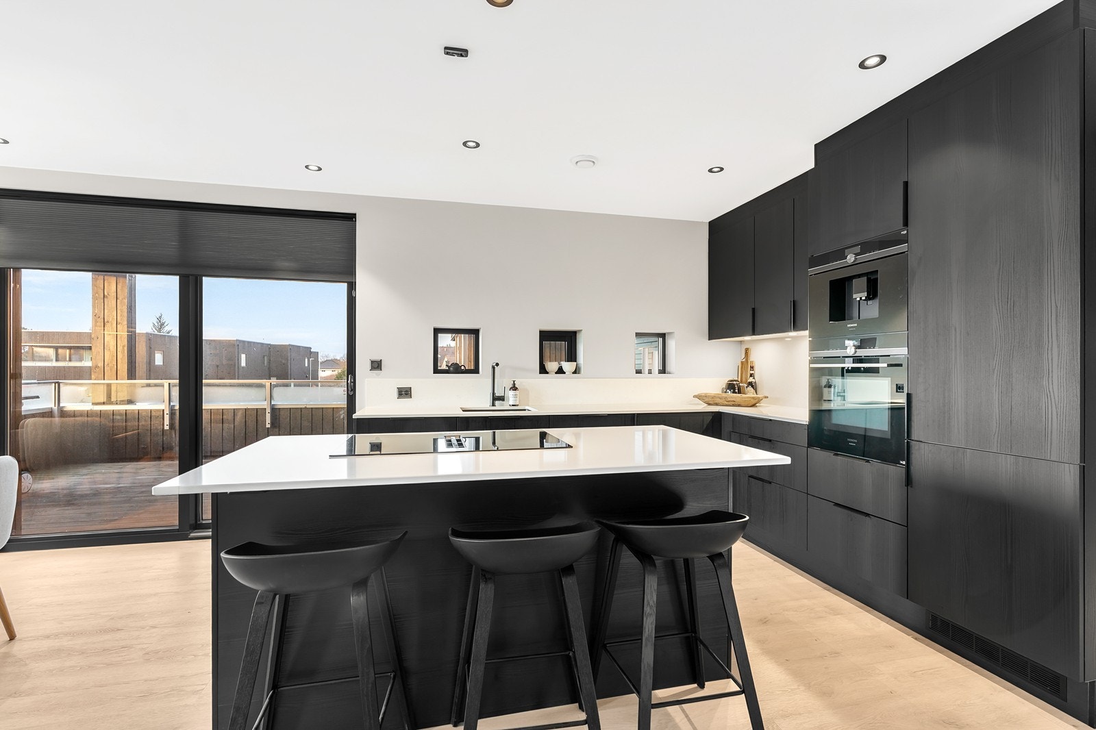 Kjøkkenet er velutstyrt med integrerte hvitevarer, herunder kjøl/fryseskap, oppvaskmaskin, induksjonstopp, stekeovn og vinskap Galleribilde