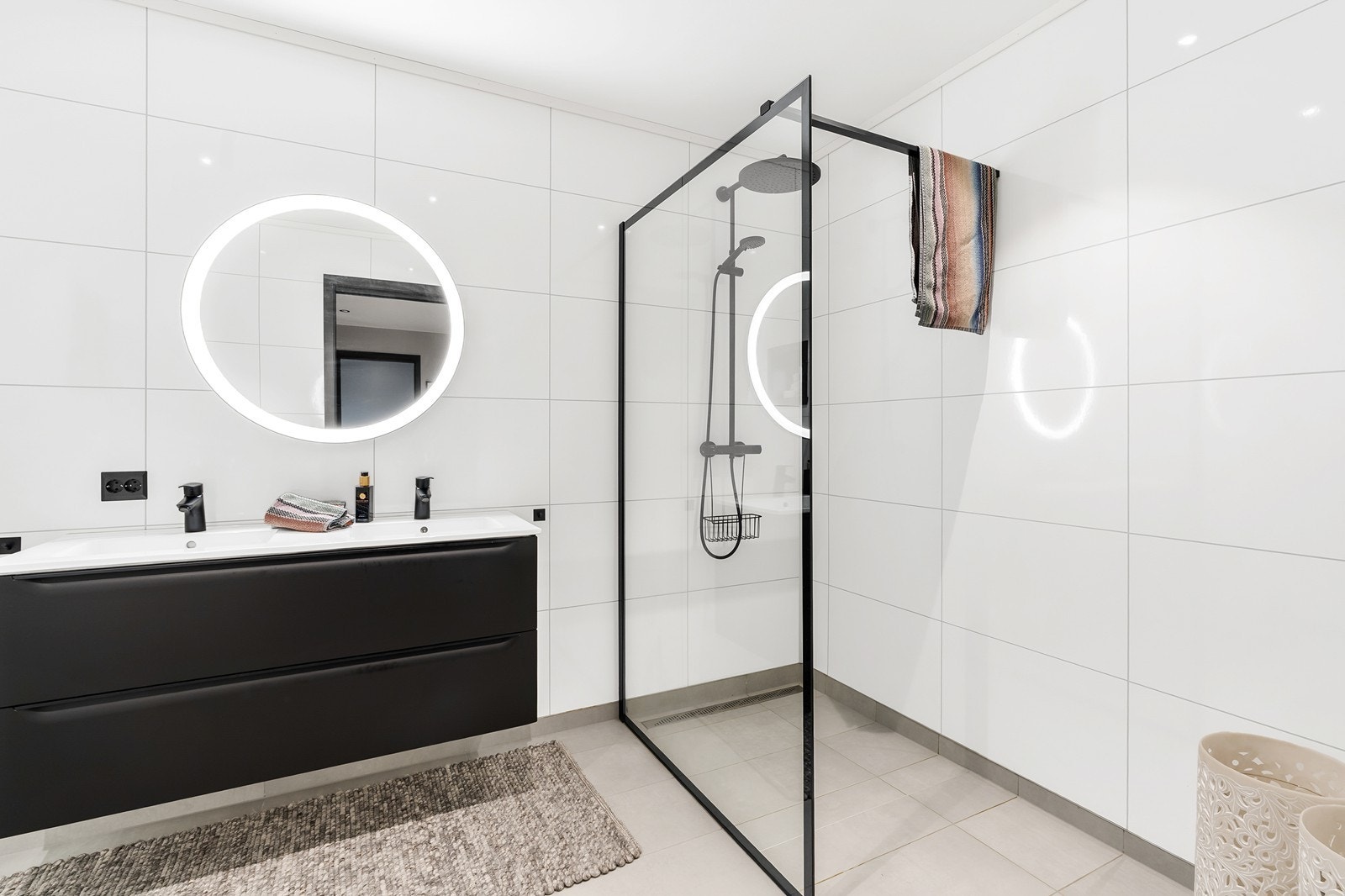 Badet er innredet med vegghengt toalett, dusjhjørne med slukrenne langs vegg samt baderomsinnredning med dobbel servant. Galleribilde