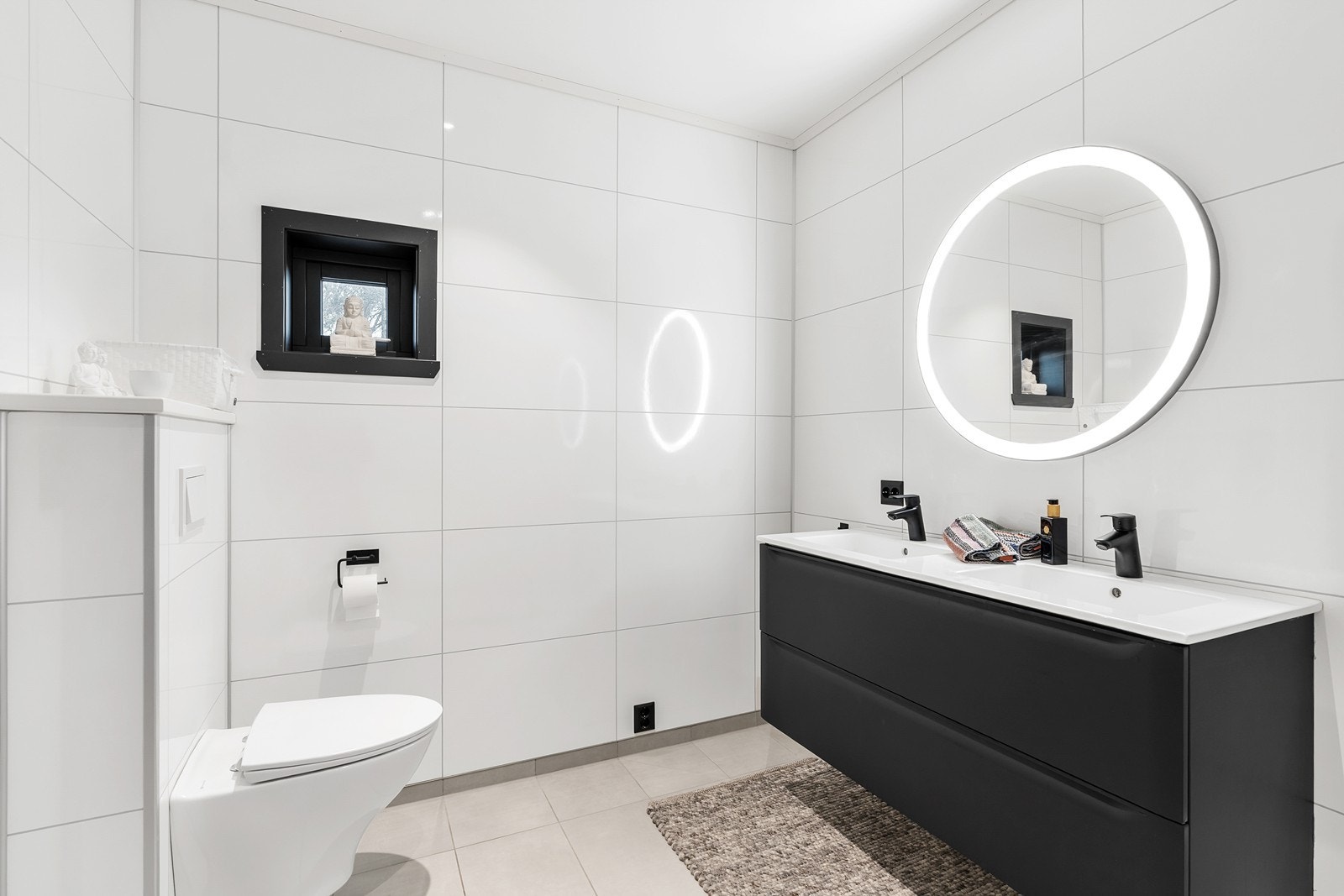 Pent og romslig bad med flislagt gulv med varmekabler, baderomsplater på vegger og malte himlingsplater med innfelte spotter. Galleribilde