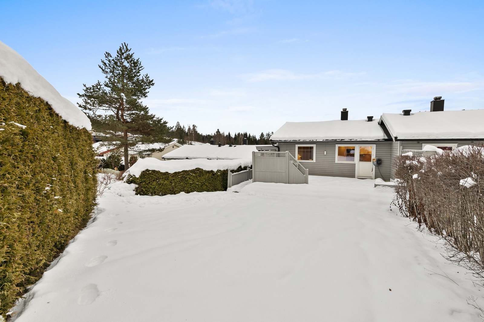 Terrassen er belagt med terrassebord og har levegg samt hyggelig utebelysning Galleribilde