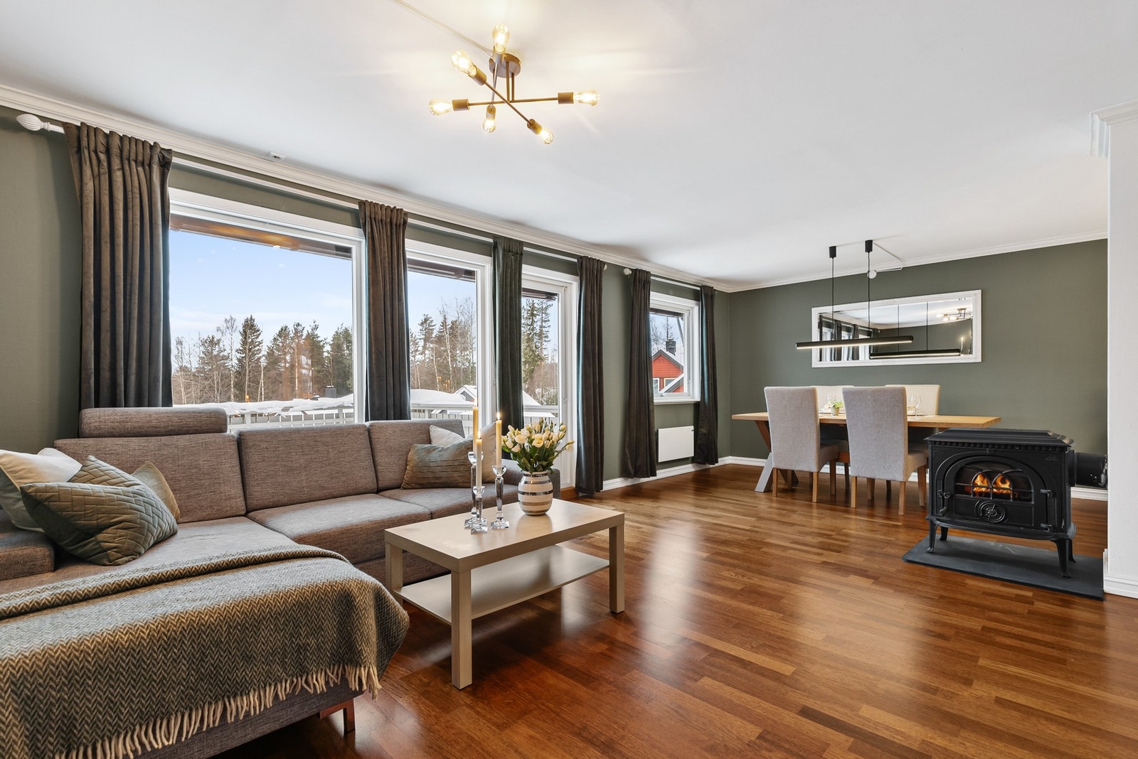 Lys og innbydende stue med parkettgulv, malt strietapet på vegger og slett flate i himling Galleribilde