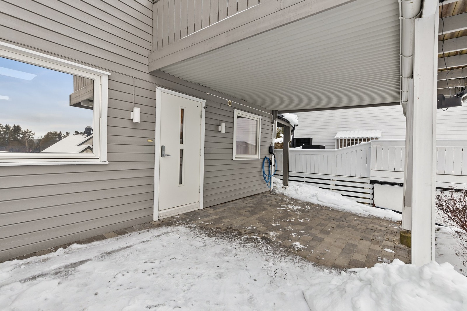 Utenfor entréen er det et overbygd inngangsparti og platting på ca. 29 kvm, belagt med betongheller Galleribilde