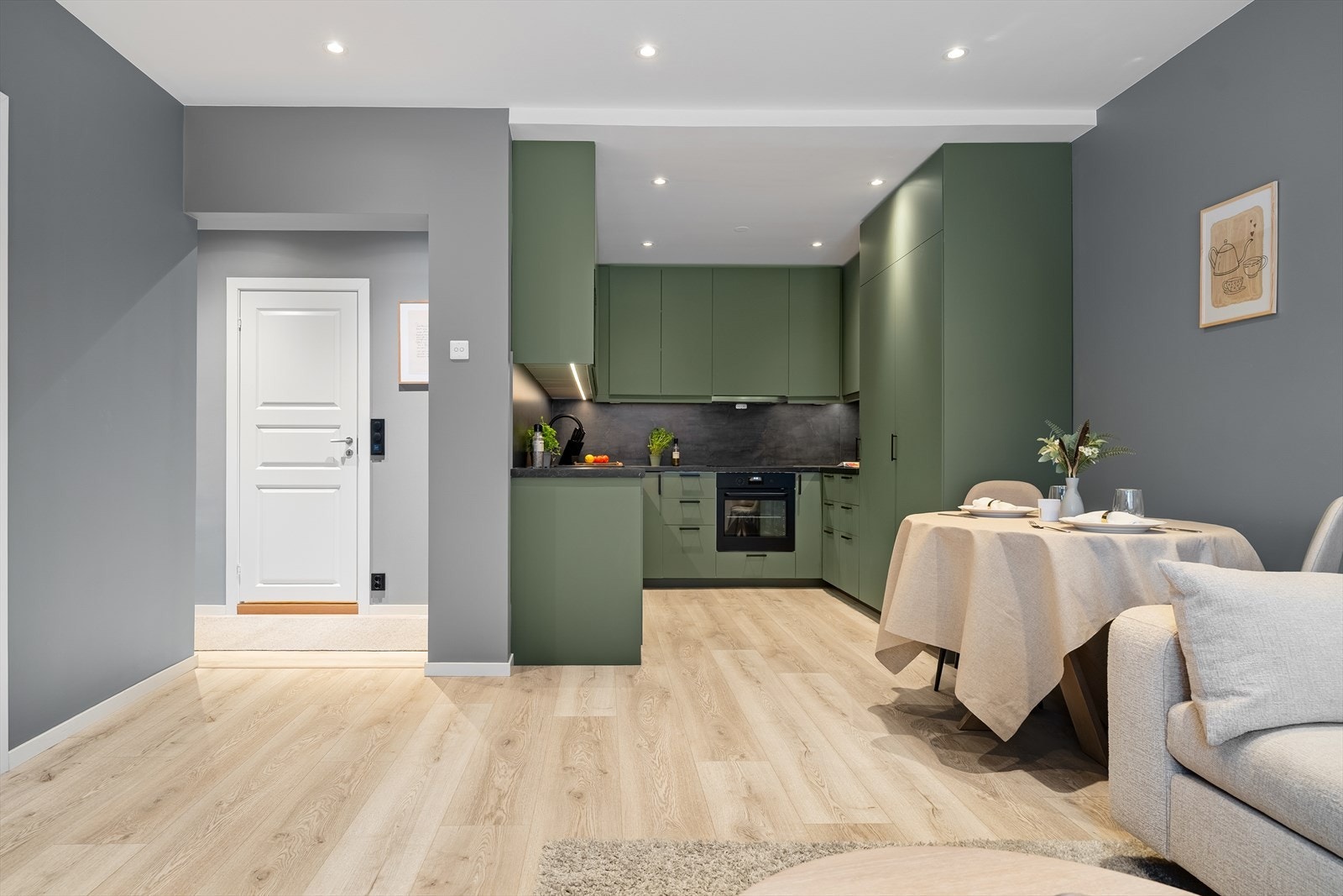 Den åpne stue- og kjøkkenløsningen skaper en sosial sone der matlaging og samvær går hånd i hånd. Galleribilde