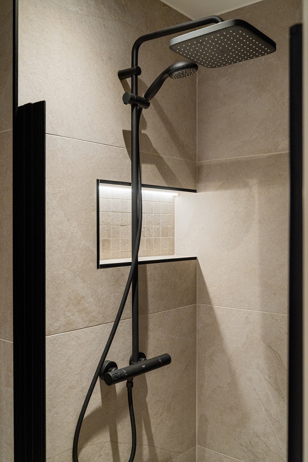 Moderne dusjsone med innfelt nisje og gjennomført materialbruk. Galleribilde