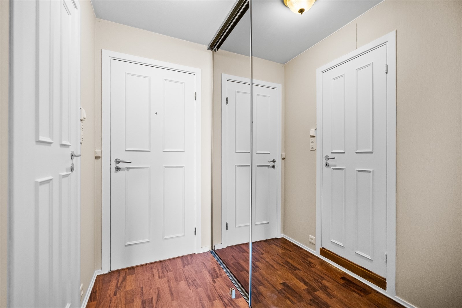 Langs vegg er det montert en praktisk skyvedørsgarderobe som gir gode oppbevaringsmuligheter. Skyvedørene er plassbesparende og bidrar til et stilrent og helhetlig uttrykk, samtidig som garderobeløsningen utnytter arealet effektivt. Galleribilde