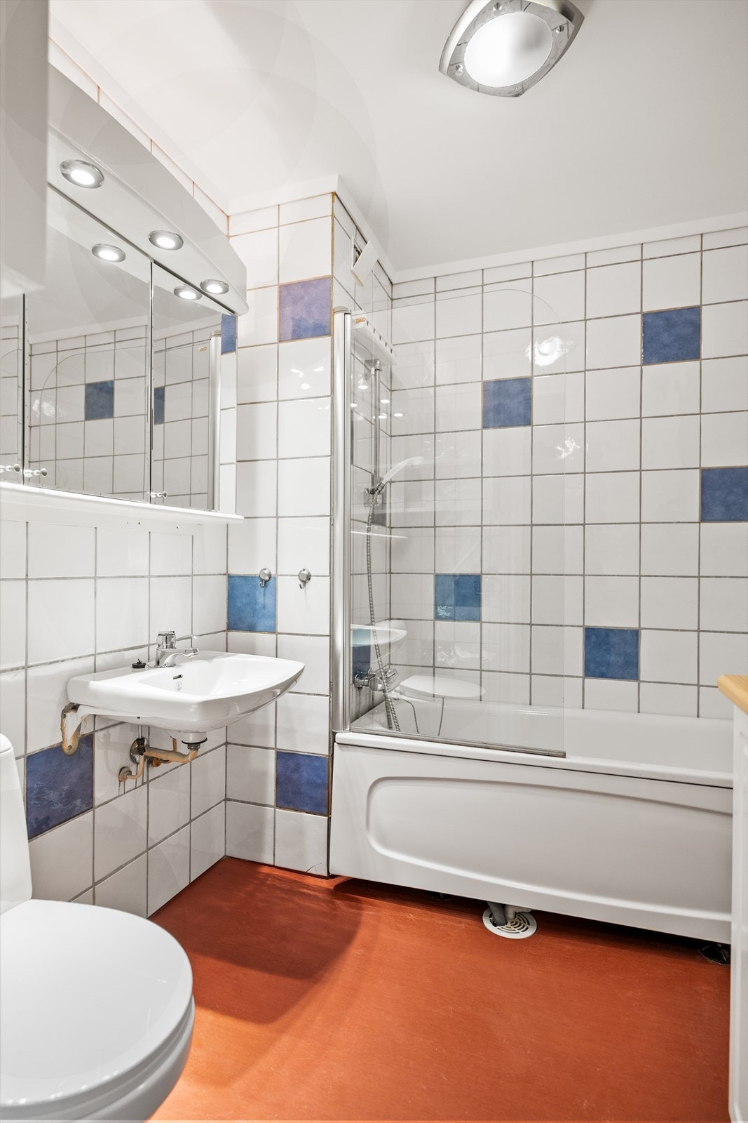 Veggene er flislagt, noe som både bidrar til et helhetlig uttrykk og sikrer robuste og fuktbestandige flater. Himlingen består av malt, slett tak som gir et rent og ryddig inntrykk. Galleribilde