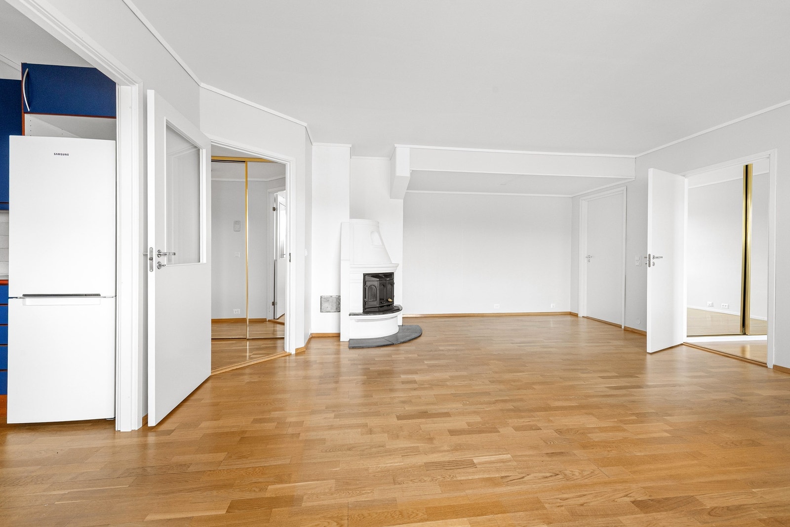 Stue med peis og dels åpen løsning mot kjøkken Galleribilde