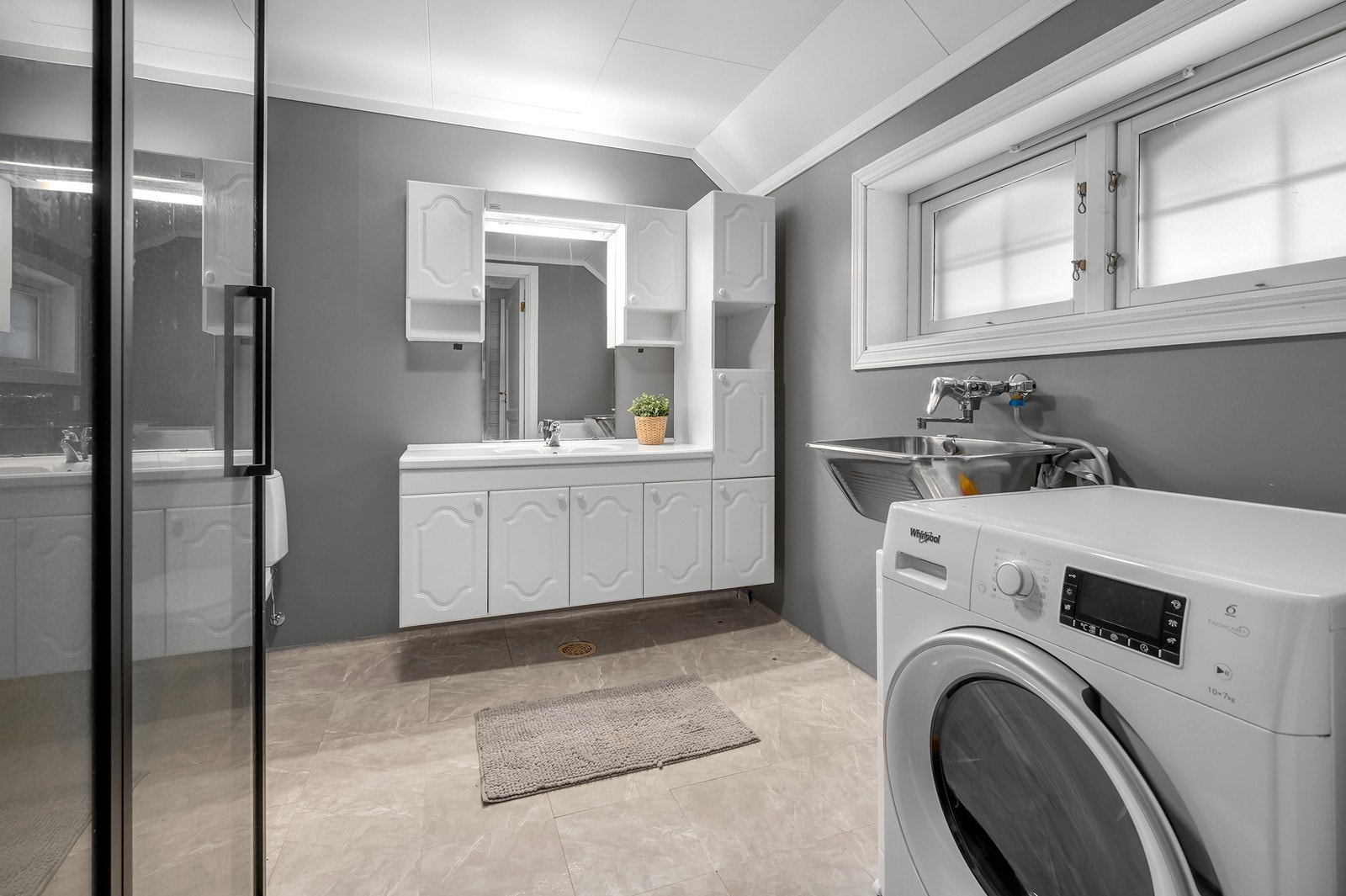 Baderommet i etasjen har servant med tilhørende innredning, toalett, dusjhjørne samt utslagsvask og opplegg til vaskemaskin. Galleribilde