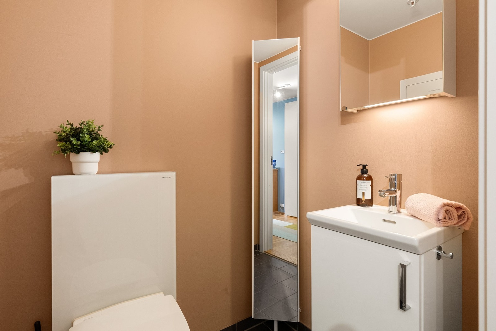 Toalettrommet er innredet med servantskap med heldekkende servant, speilskap og vegghengt toalett. Galleribilde