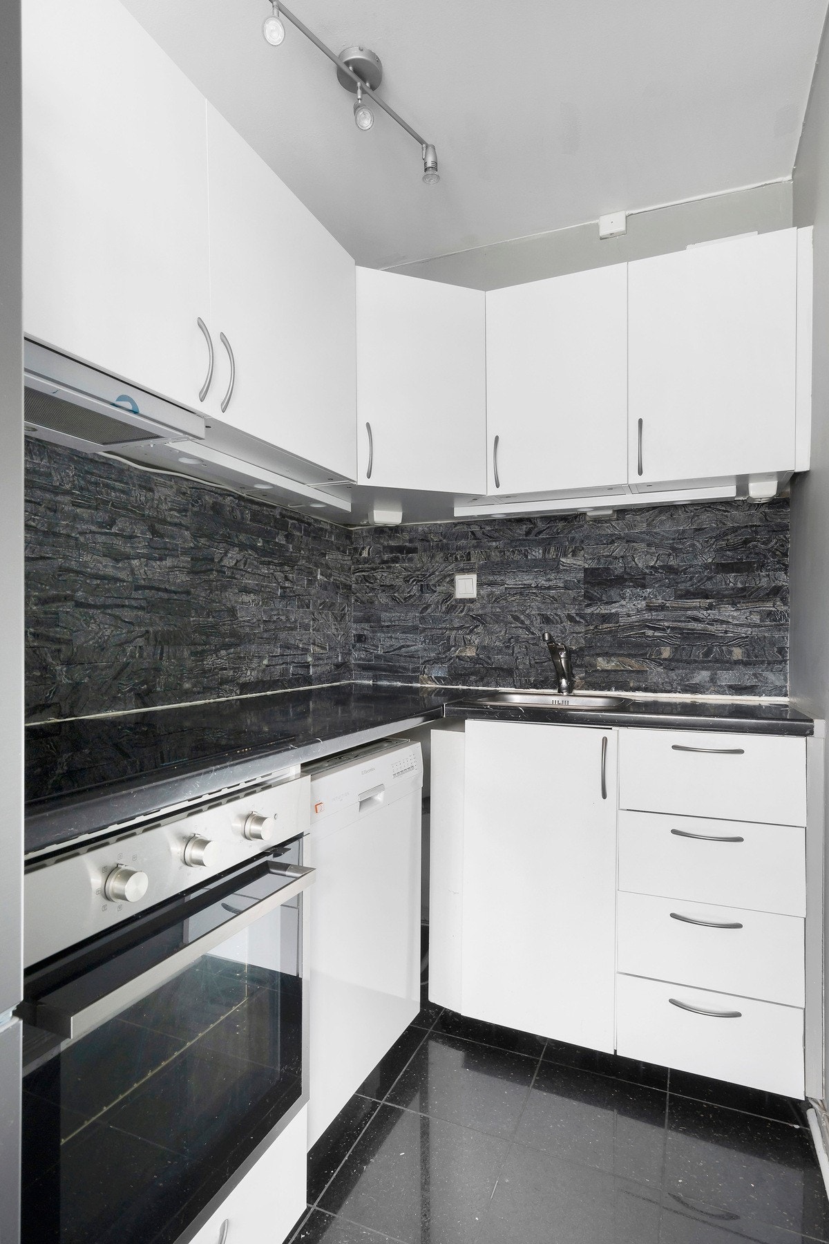 Lyst kjøkken med innredning fra IKEA med glatte fronter og laminat benkeplate. Galleribilde