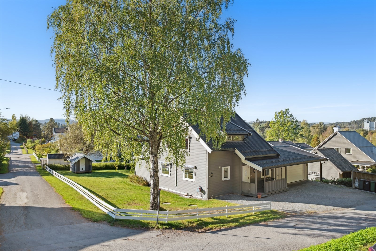 Stor gårdsplass og delvis inngjerdet hage. Inngangspartiet er pent opparbeidet med overbygg og en innrammet platting. Galleribilde