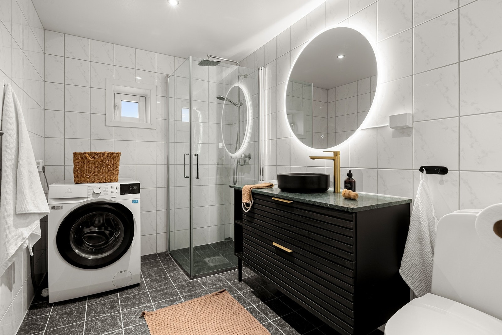 Badet er på ca. 5,2 kvm og er flislagt på gulv og vegger, med spotter i tak. Galleribilde