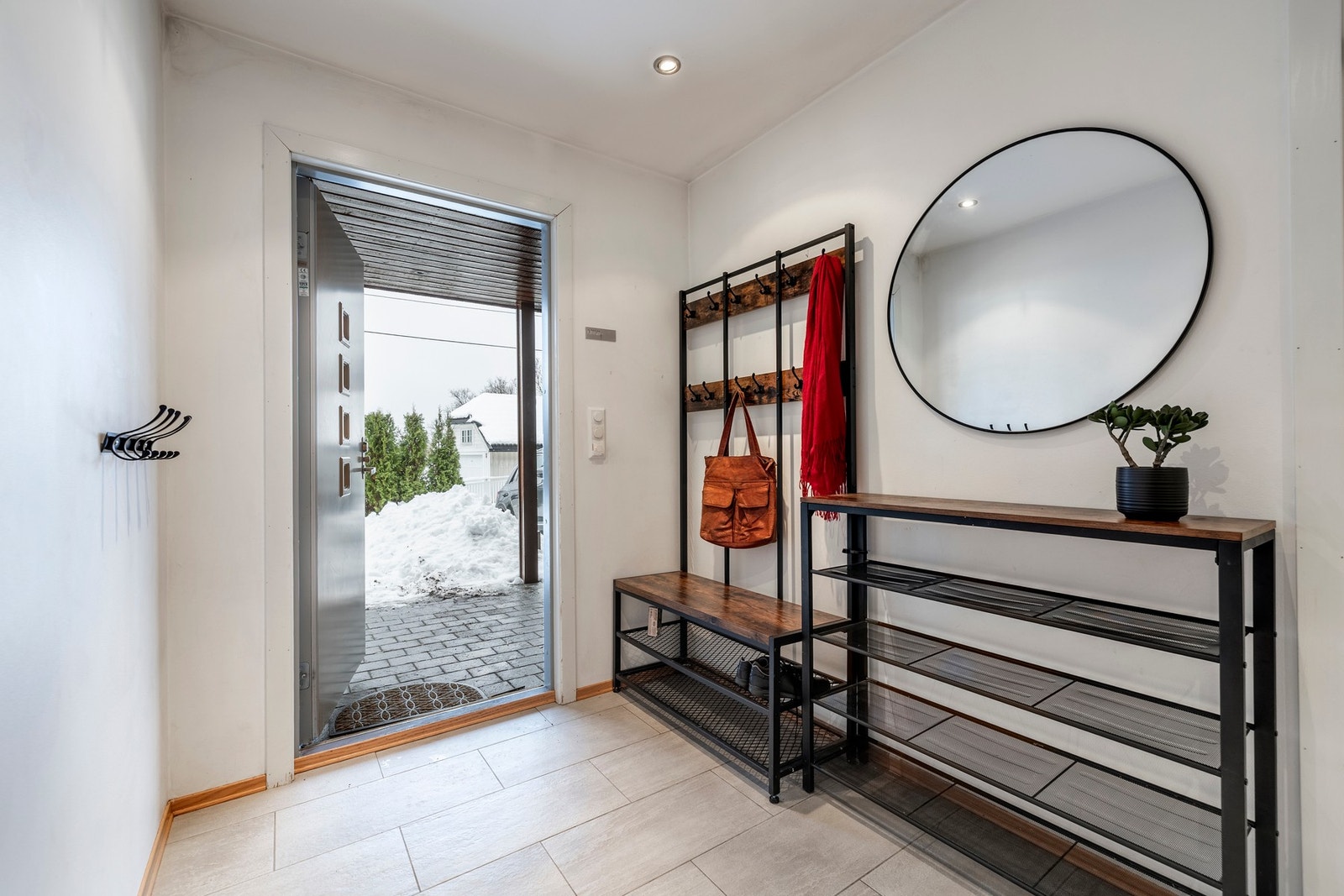 Entréen har downlights og lysegrå fliser på gulvet, utstyrt med varmekabler for ekstra komfort. Galleribilde