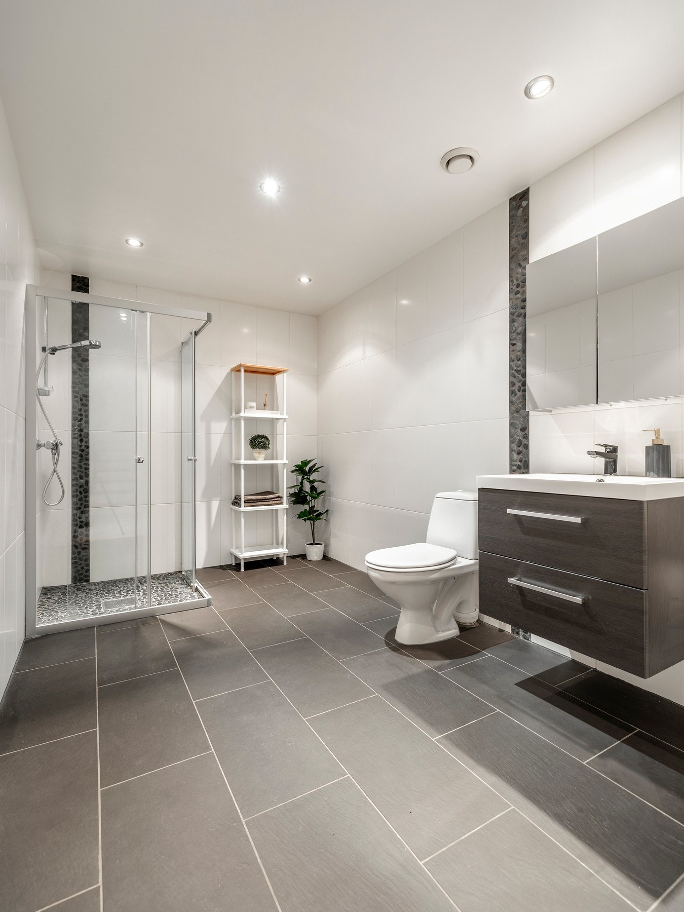 Badet er utstyrt med flislagte vegger- og gulv, varmekabler og innfelt downlights. Galleribilde