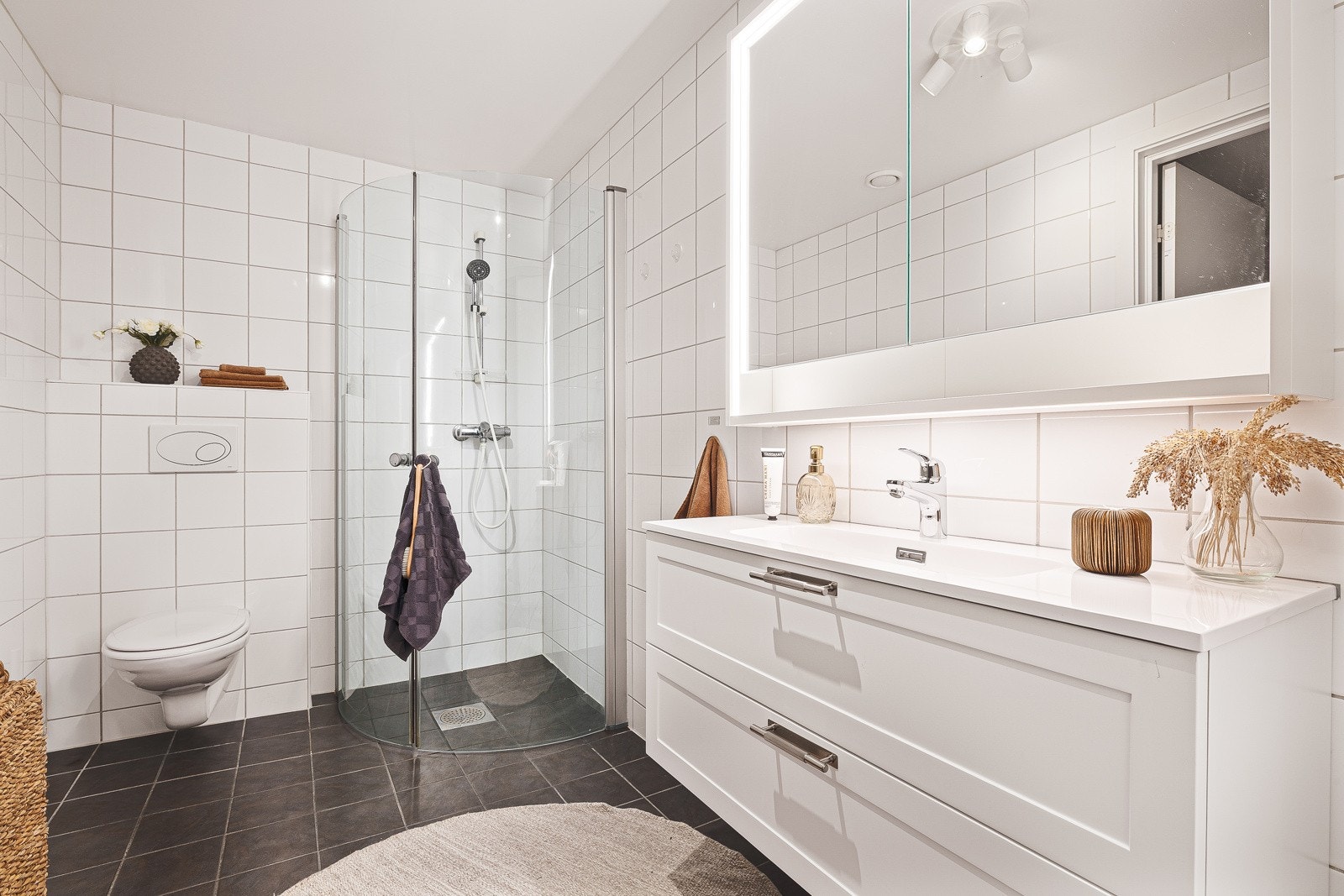 Pent helfliset bad med nytt lekkert baderomsmøbel og speilskap med belysning. Galleribilde