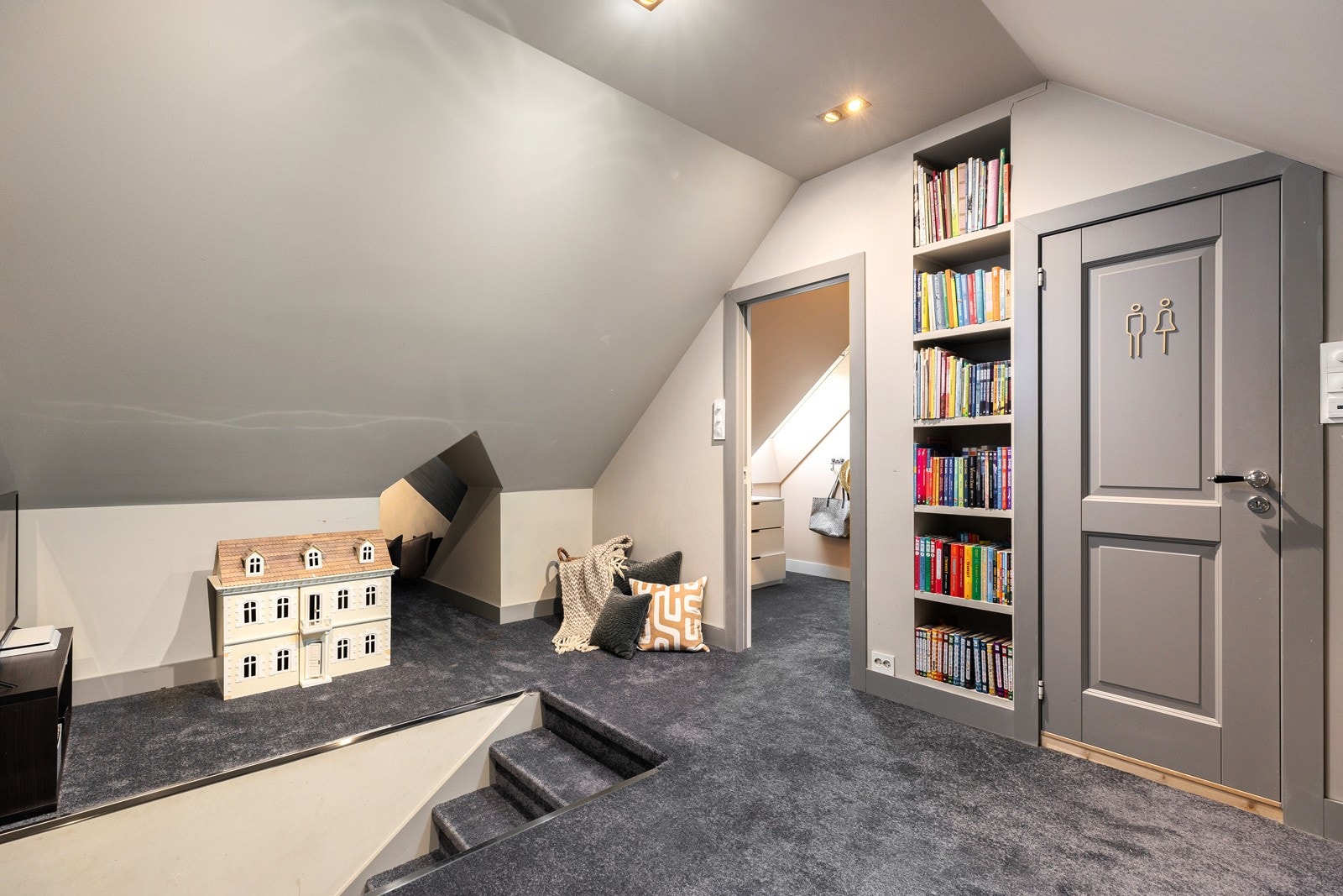 Gangen på loftet (ikke byggemeldt) har gulvteppe, downlights, samt inngang til to soverom og et bad.