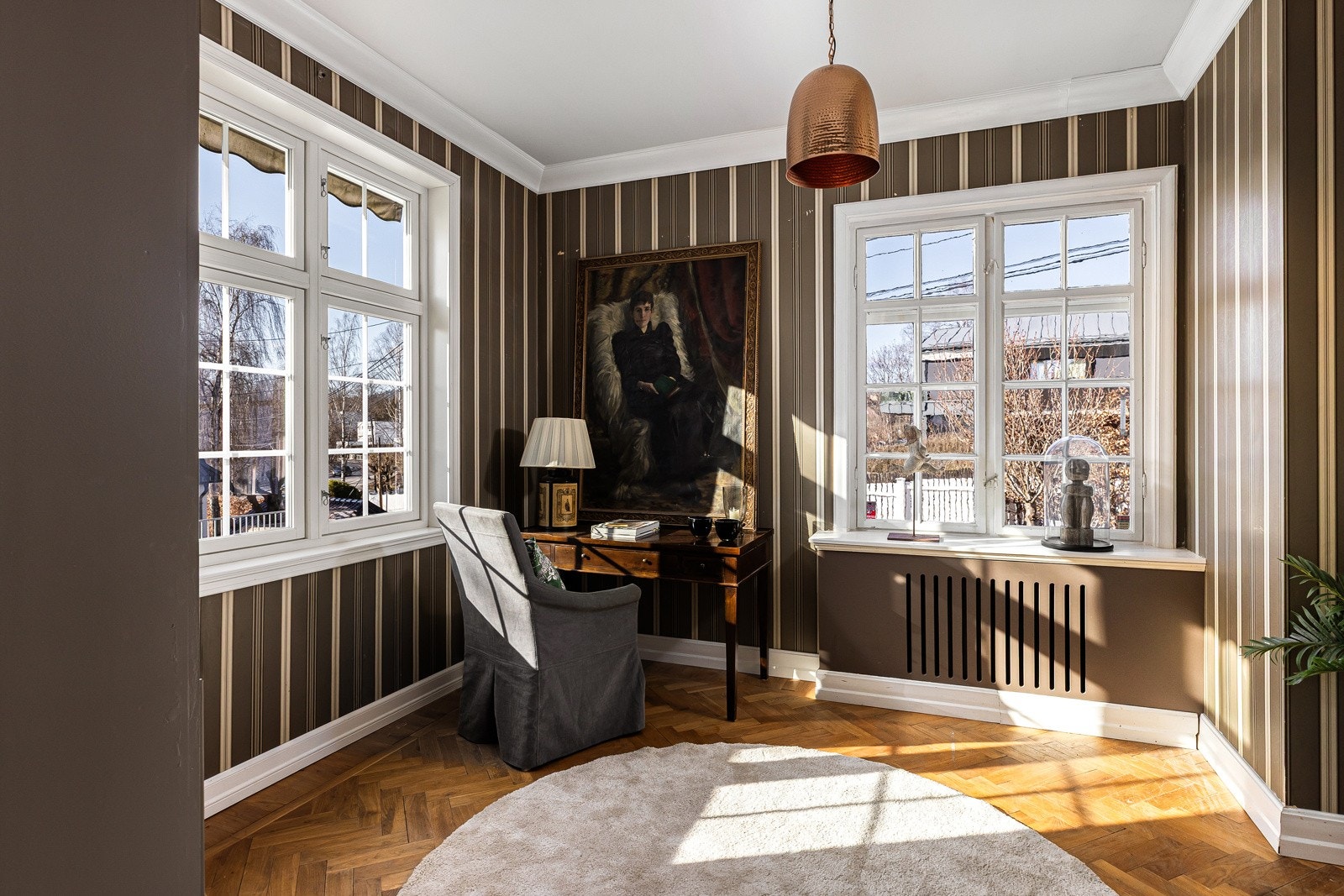 Biblioteket og stuene har parkett i fiskebensmønster, luftig takhøyde og varme fra innebygde radiatorer.