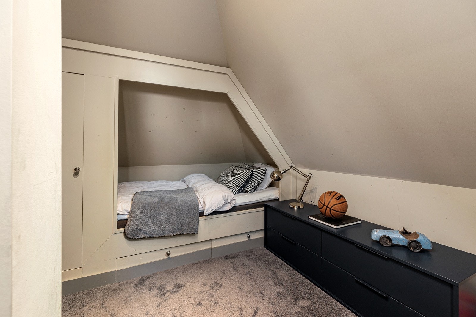 Det andre soverommet på loftet har en snekkerbygd sengealkove med skap og skuffer.