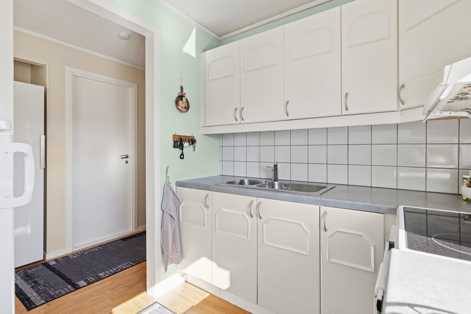 Benkeplaten er i laminat, utstyrt med en oppvaskkum av stål og ettgreps blandebatteri. Galleribilde