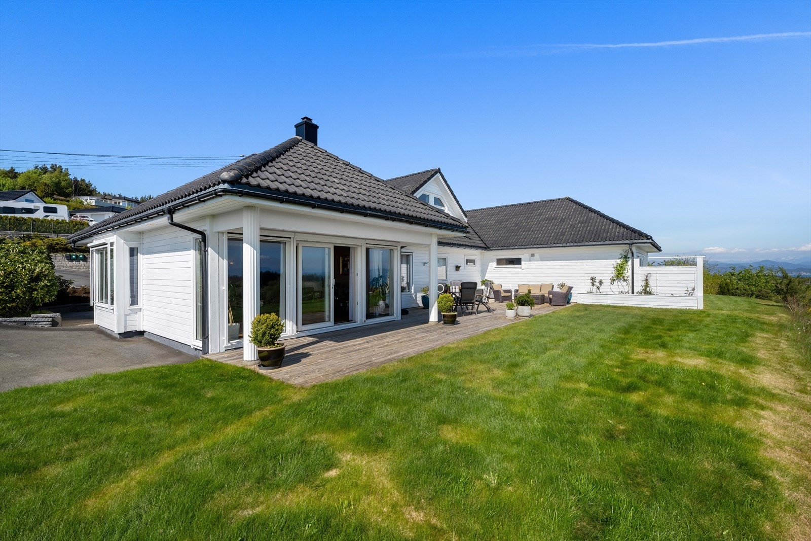 Eiendommen har store treterrasser i tillegg til gressplen. Du kan også nyte en fantastisk utsikt Galleribilde