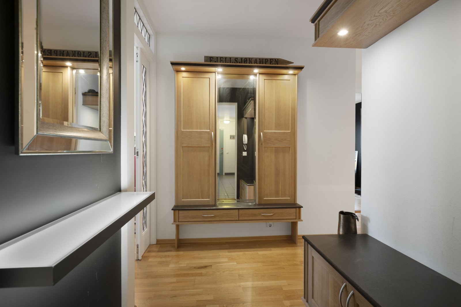 Leiligheten har heisadkomst til etasjeplan, noe som gir enkel tilgang inn til boligen. Når du trer inn, blir du møtt av en hyggelig entré som inkluderer en sittebenk, hattehylle og plass til skostativ. Galleribilde