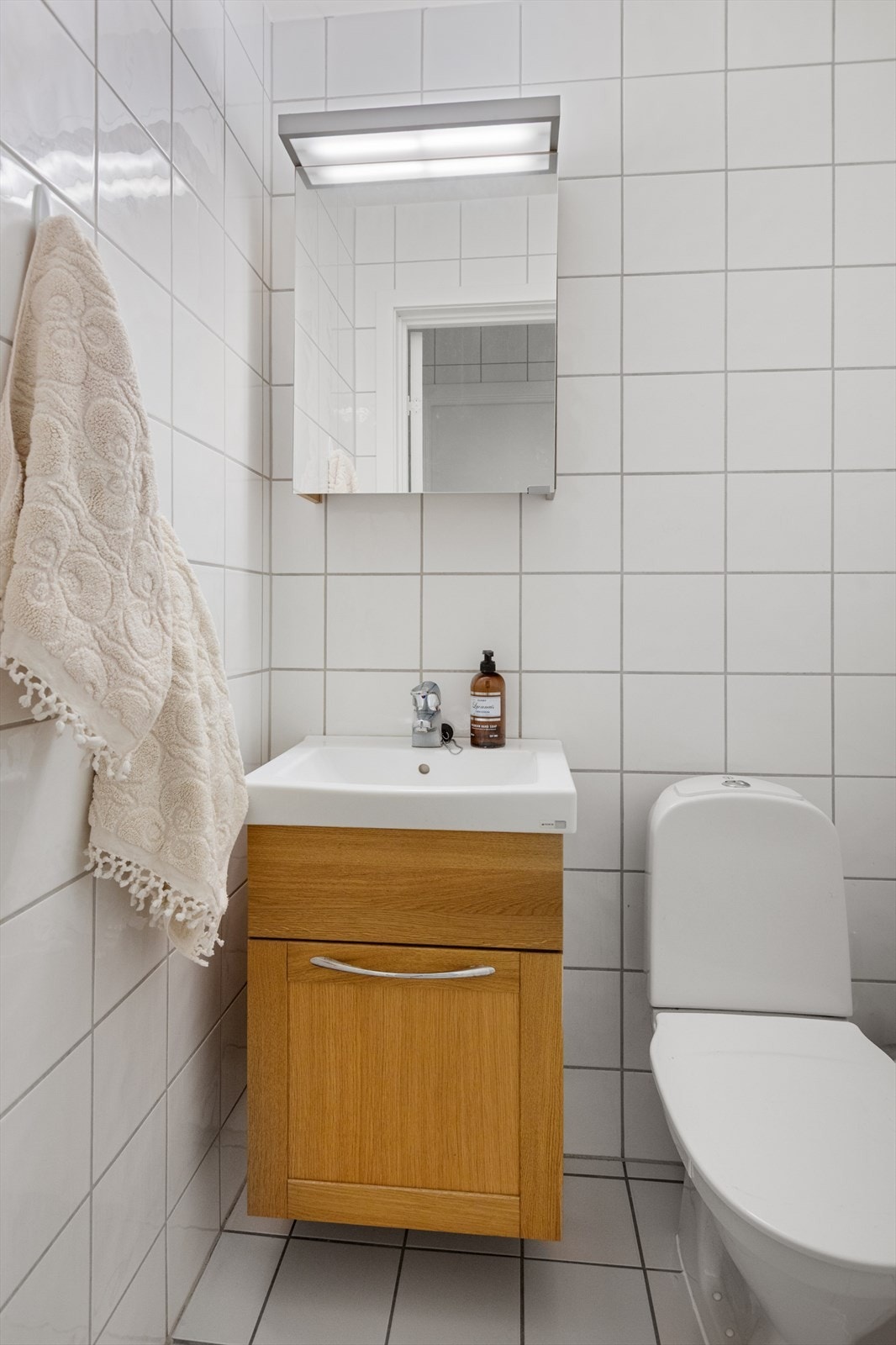 Toalettrommet er flislagt og har varmekabler i gulvet, noe som gir ekstra komfort. I tillegg er det installert en ny servantinnredning i løpet av de senere årene, som bidrar til et moderne og stilrent uttrykk. Galleribilde