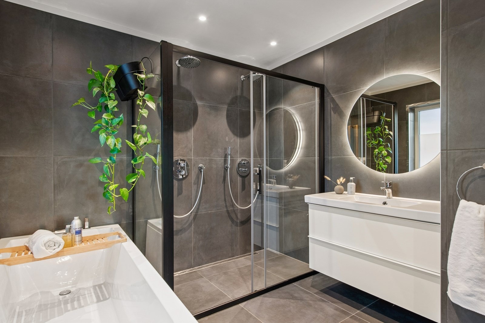 Delikat baderom med flislagte overflater, gulvvarme og downlights i himling. Galleribilde