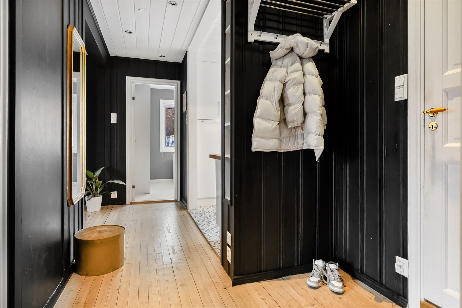 Fra felles trappegang kommer man inn i en entré med panelkledde vegger og tregulv. Galleribilde