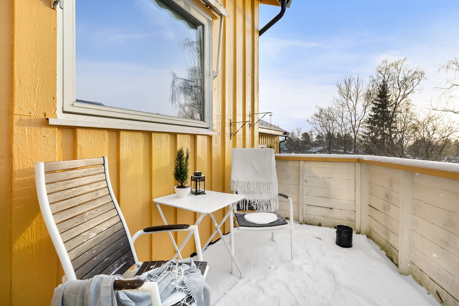 Rekkverket i treverk rammer inn uteplassen. Galleribilde