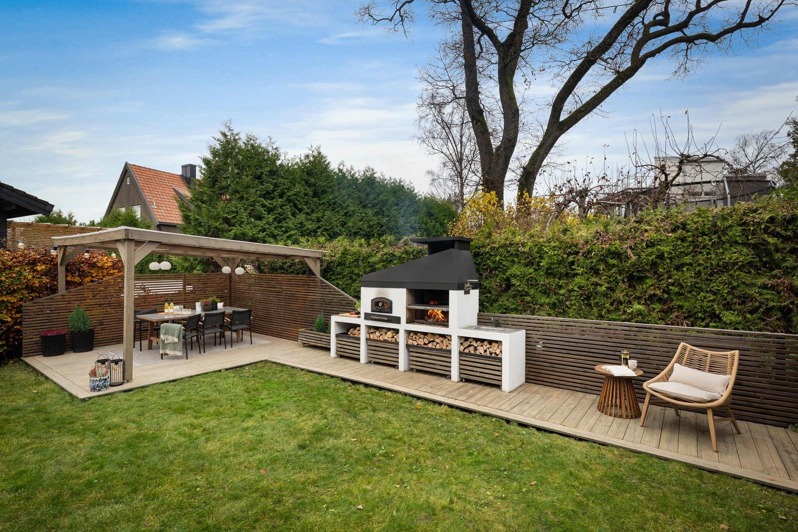 Ytterst på plenen er det etablert en flott terrasse med pergola og utekjøkken, oppført i perioden 2022/2023. Galleribilde