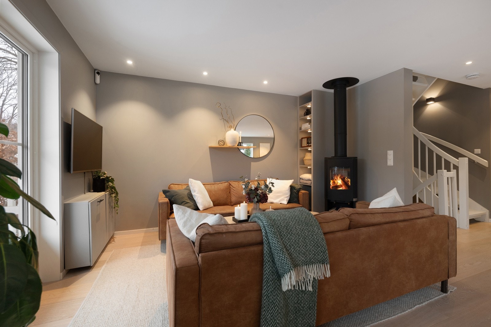 Naturlige soner for møblering av sofagruppe foran den flotte vedfyrte peisen, som både gir god varme og skaper en hyggelig atmosfære i rommet. Galleribilde