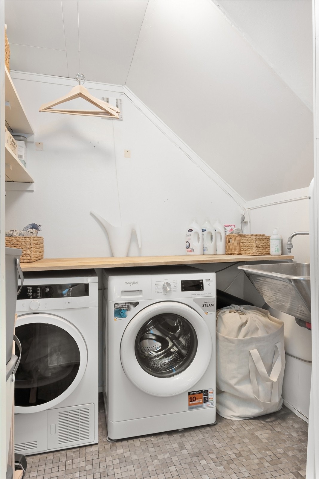 Fra entréen er det adkomst til vaskerom med enkel og funksjonell innredning. Rommet har opplegg for vaskemaskin og tørketrommel, benkeplate, hyller og utslagsvask. Galleribilde