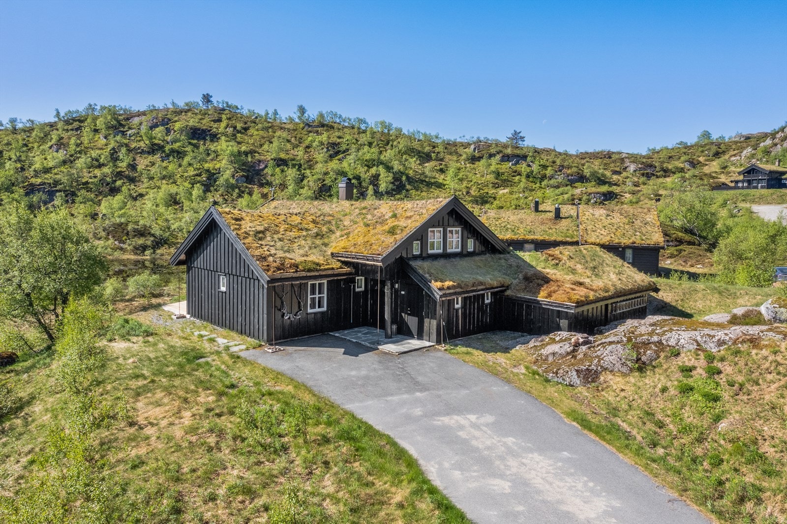 Stor oppkjørsel og inngangsparti som er hellelagt og asfaltert Galleribilde