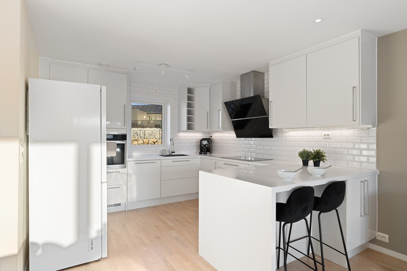 Det har integrerte hvitevarer, som oppvaskmaskin, stekeovn og platetopp, god lagringsplass og sitteplasser ved kjøkkenøyen. Galleribilde