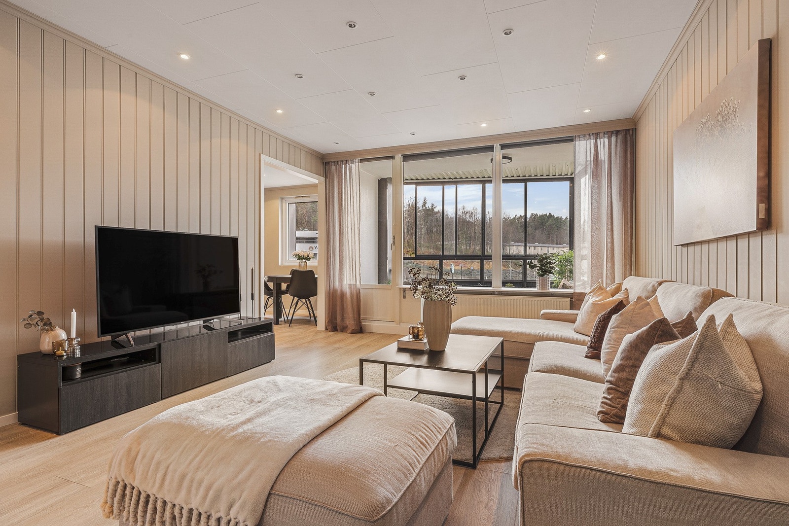 Stuen har tidsriktig fargevalg på vegger og nytt, flott laminatgulv fra 2025. Galleribilde