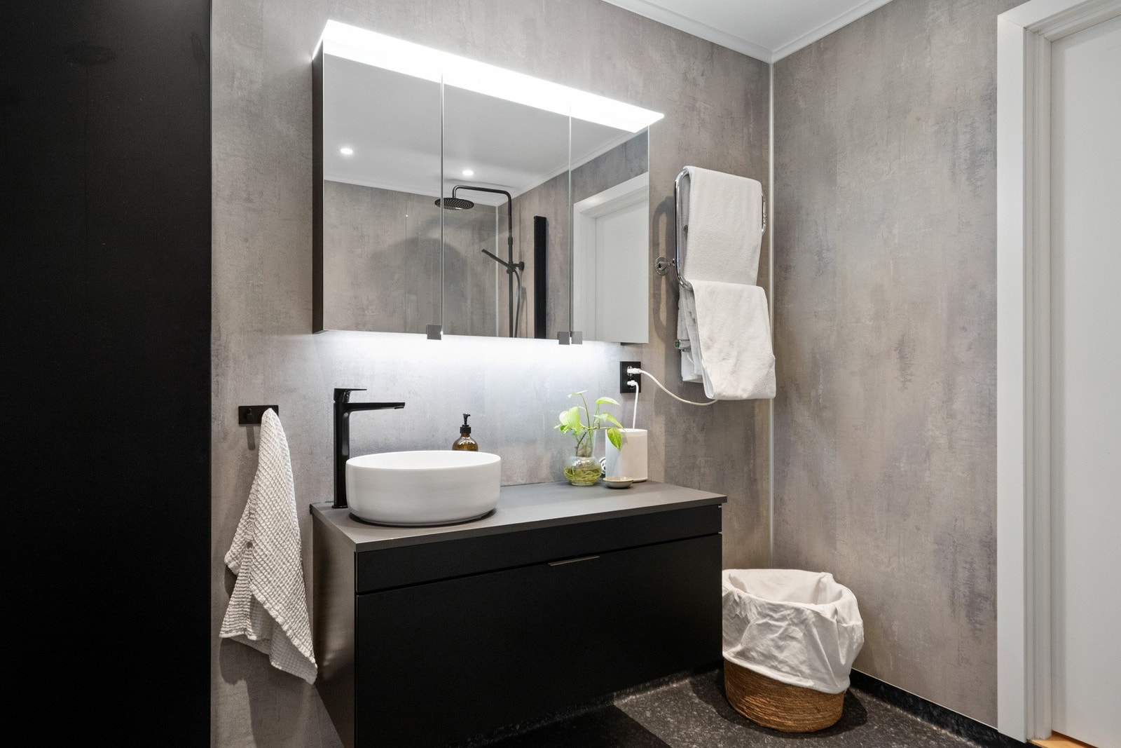 Badet er innredet med servant, badekar med dusj og veggmontert toalett, samt elektrisk styrt ventilasjon. Galleribilde