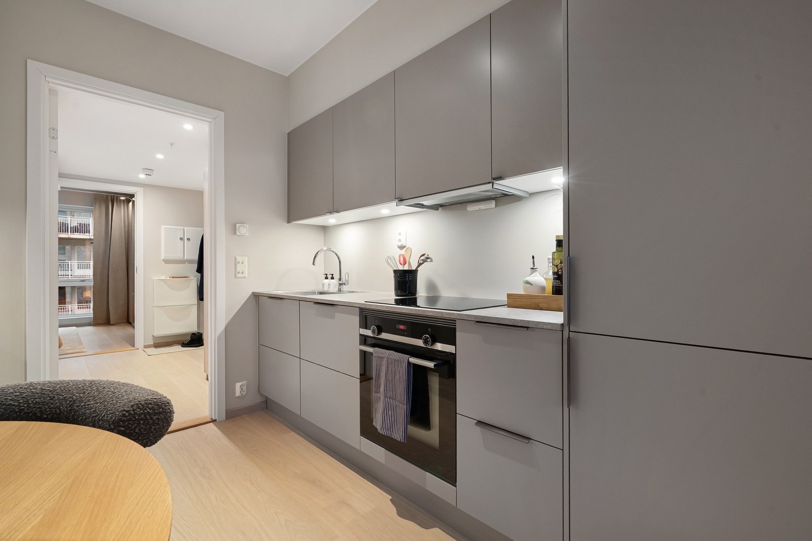 Integrerte hvitevarer som induksjonsplatetopp, stekeovn, oppvaskmaskin og kjøle fryseskap gir et ryddig og helhetlig kjøkken, akkurat slik det skal være. Galleribilde