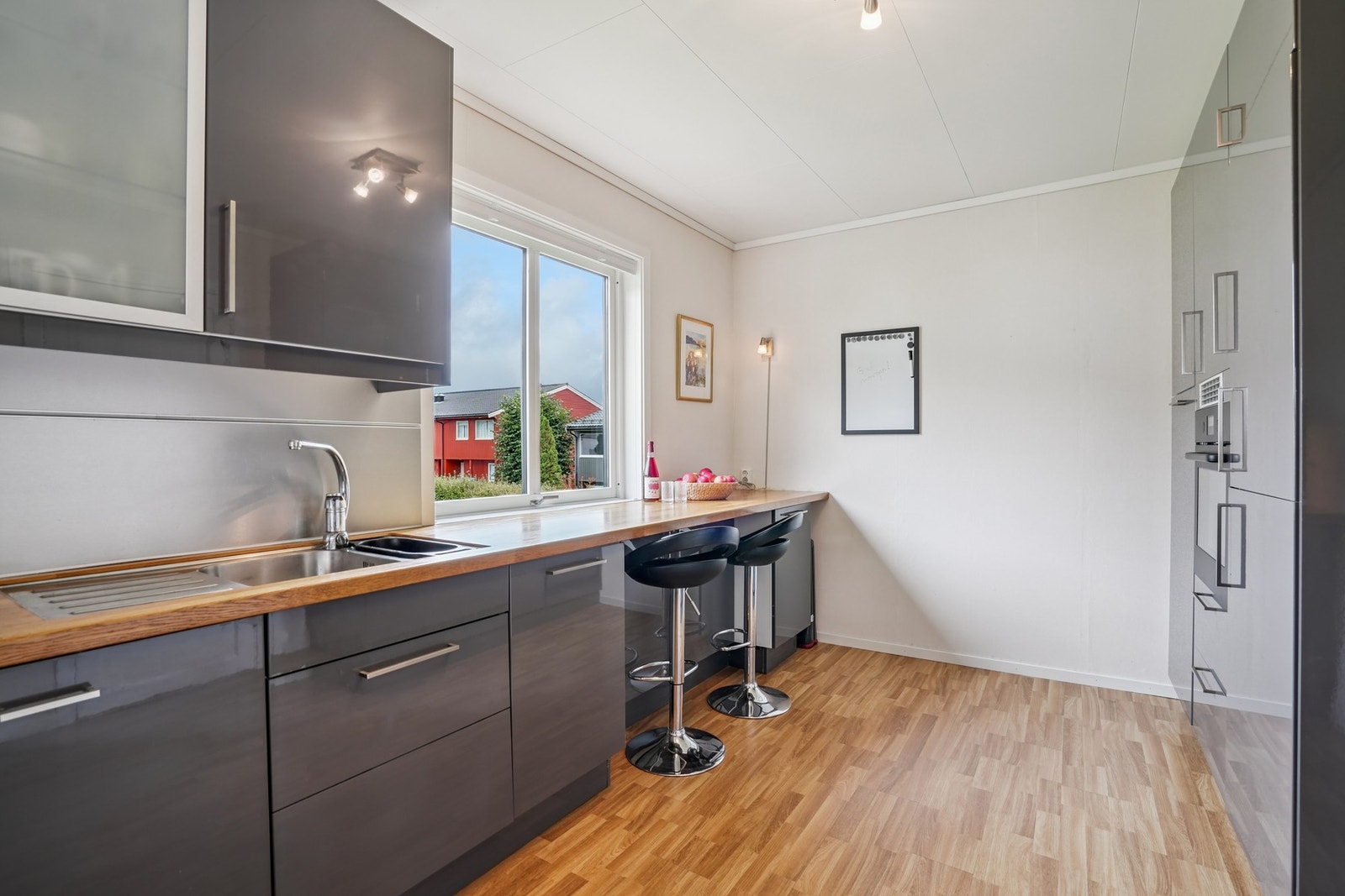 Kjøkkenet har integrerte hvitevarer som induksjon platetopp, kjøleskap og oppvaskmaskin - Galleribilde