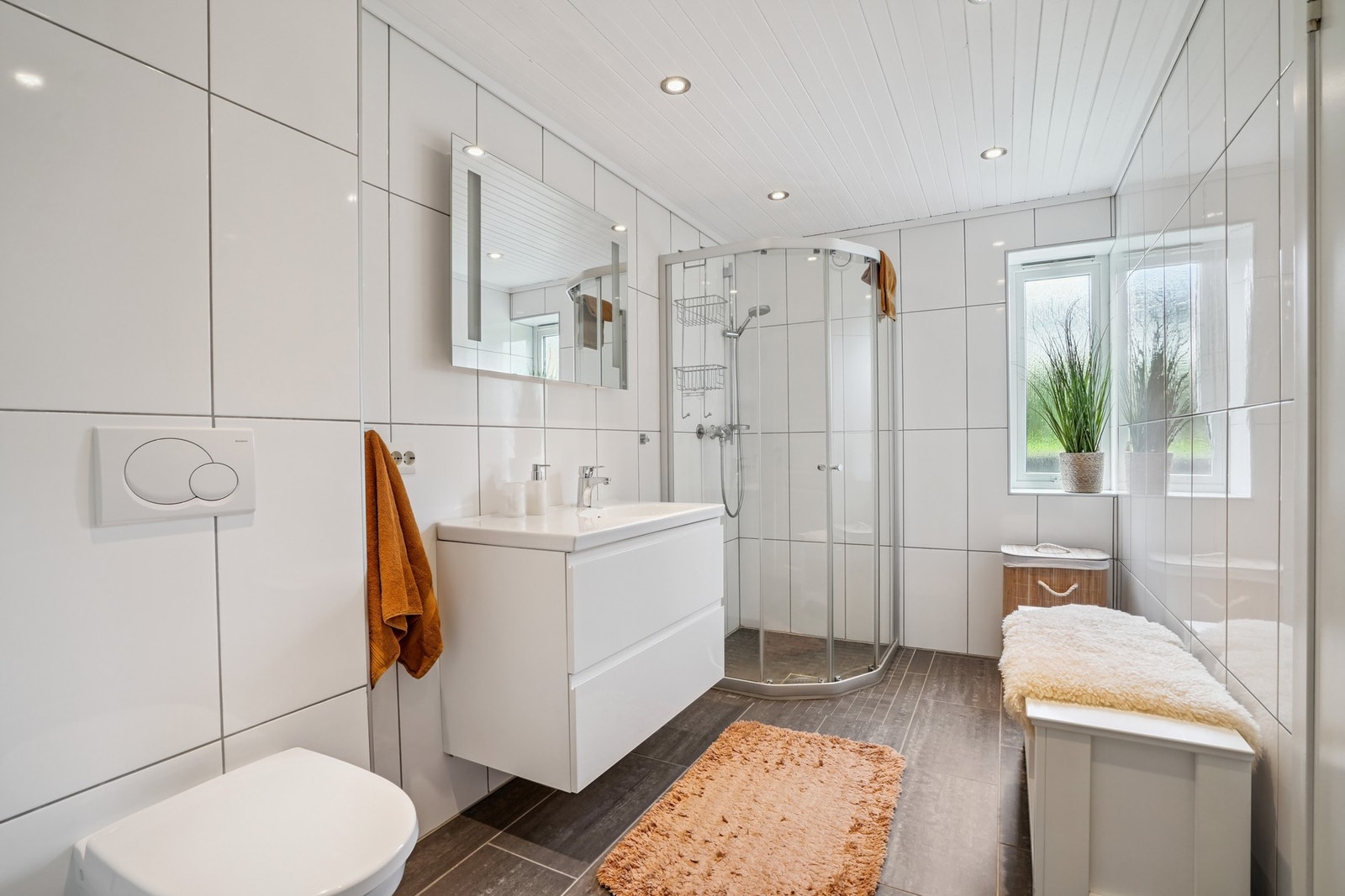 Lyst helfliset bad fra 2012 med elektriske varmekabler. I himling er det ledspotter med dimming. Galleribilde