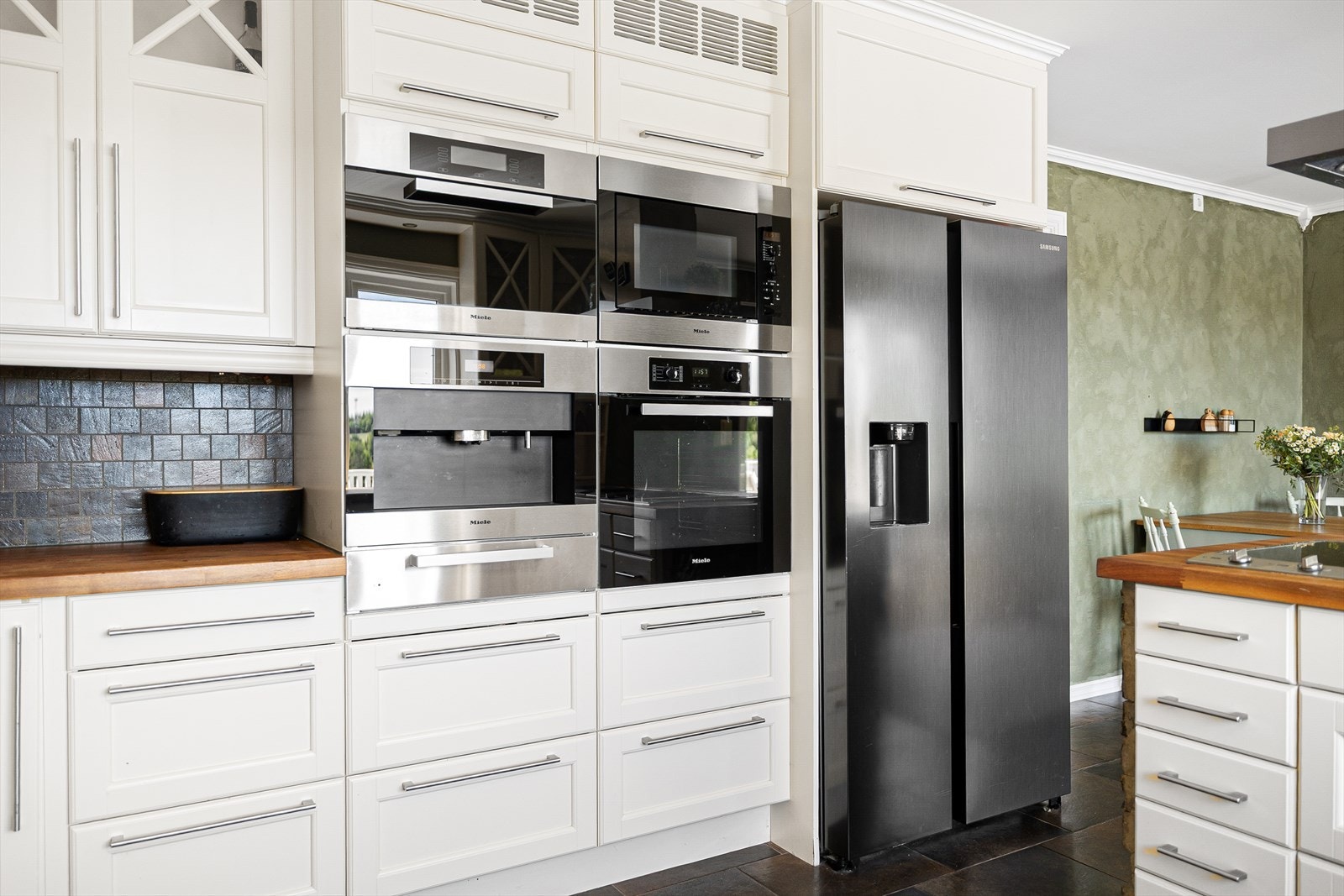 Integrerte hvitevarer som blant annet vinskap, stekeovn, kaffemaskin og wok/grill. Galleribilde