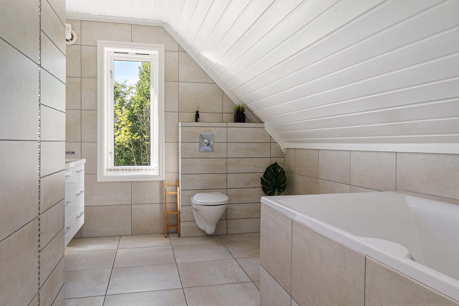 Et elegant bad med tidløse farger på flisene og et klassisk badekar. Galleribilde