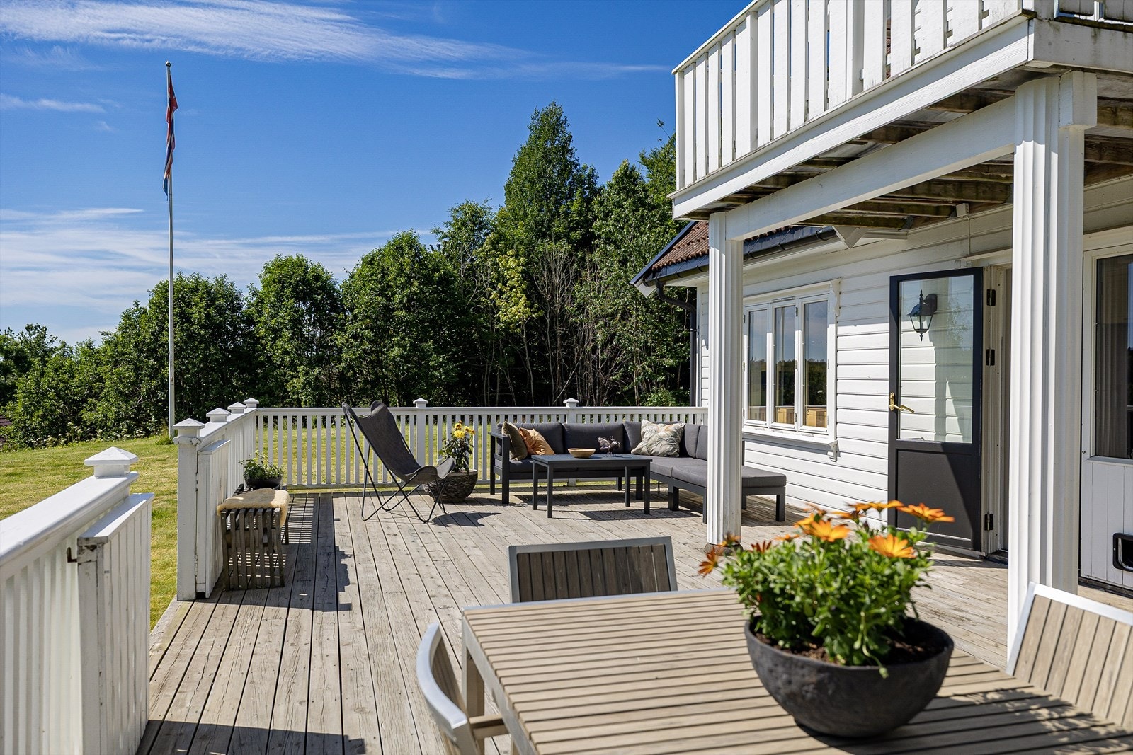 En romslig terrasse med solrike forhold og vakker, landlig utsikt - perfekt for avslapning og sosiale stunder. Galleribilde