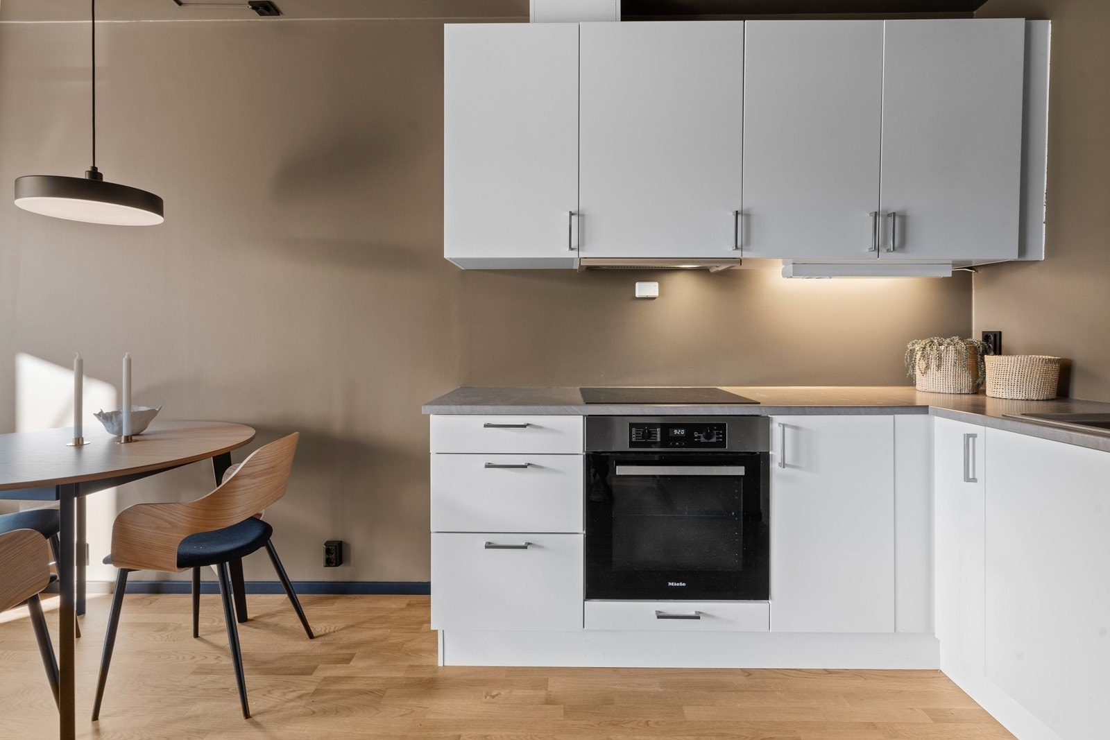 Kjøkkeninnredning fra byggeår. Kjøkkenet har slette fronter og laminat benkeplate. Integrert komfyr, platetopp, kjøl/fryseskap og oppvaskmaskin. Galleribilde