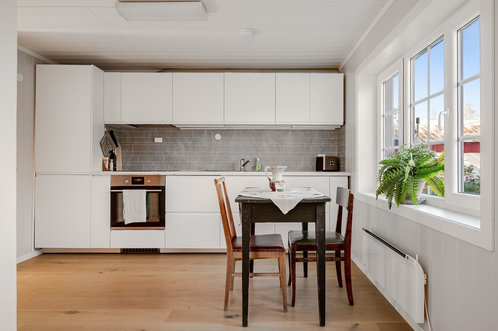 Lys kjøkkeninnredning fra 2018 med.glatte fronter og laminert benkeplate med nedfelt oppvaskkum. Kjøkkenet er utstyrt med medfølgende integrerte hvitevarer. Galleribilde