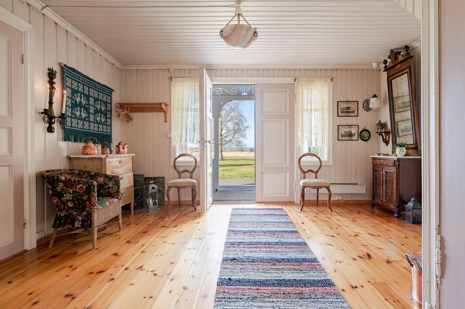 Når du entrer boligen kommer du inn i en romslig hall med lakkerte tregulv og vedovn. Galleribilde